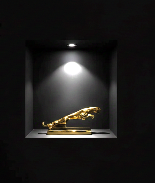 gouden jaguar in zwarte vakkenkast Beeld Jaguar Goud