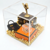 Een handgemaakt miniatuur kunstwerk genaamd Luxury Cube in een heldere acrylglas display 10 cm, met een gouden Spirit of Ecstasy, iconische mini-handtas en gouden kralen.