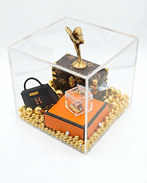 Luxury Cube Een handgemaakt miniatuur kunstwerk genaamd Luxury Cube in een heldere acrylglas display 10 cm, met een gouden Spirit of Ecstasy, iconische mini-handtas en gouden kralen.