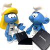 Pop-art kunstwerk Luxury Present for Smurfin door Geov, met Smurfin en een Smurf, een handgemaakt zwart lederen Chanel mini-tasje en een luxe Chanel doosje.